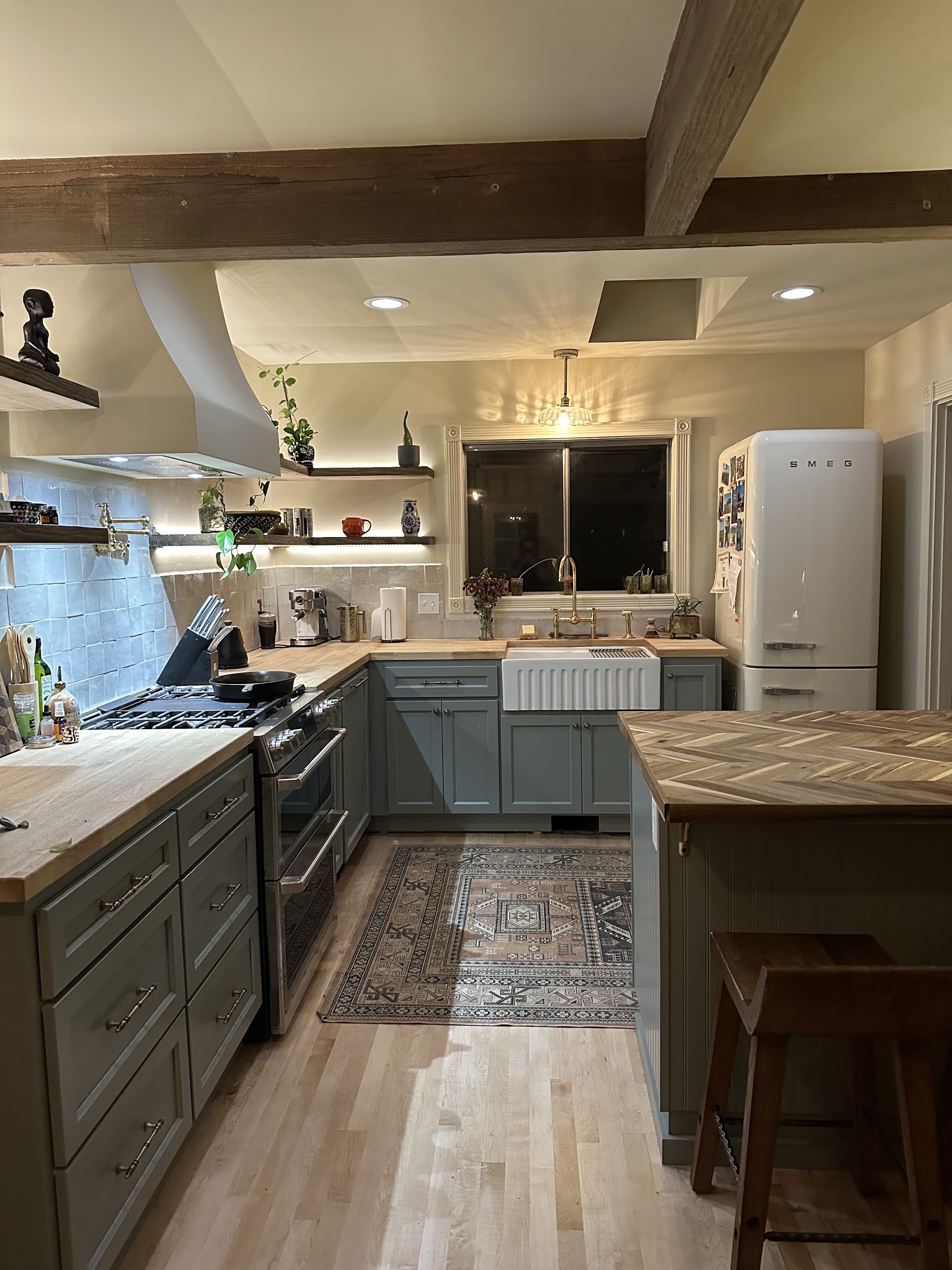 High-end kitchen remodel with custom range hood and herringbone butcher block counter by Roth Construction